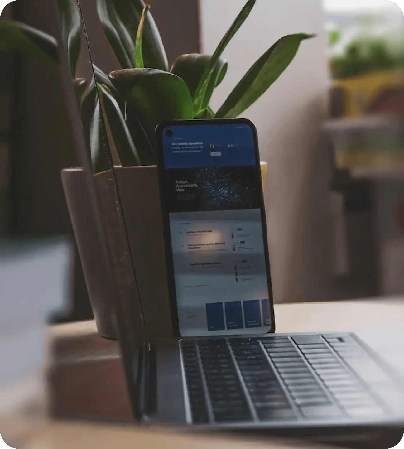 An image of a laptop and iphone in a workspace to demonstrate a developers workspace.