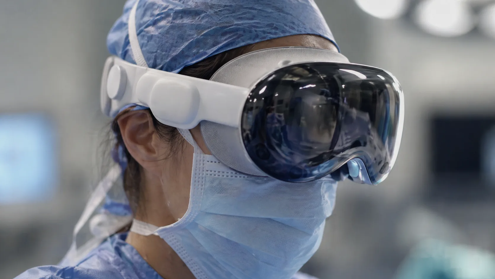 Surgeon wearing Apple Vision Pro during operation in modern operating room.