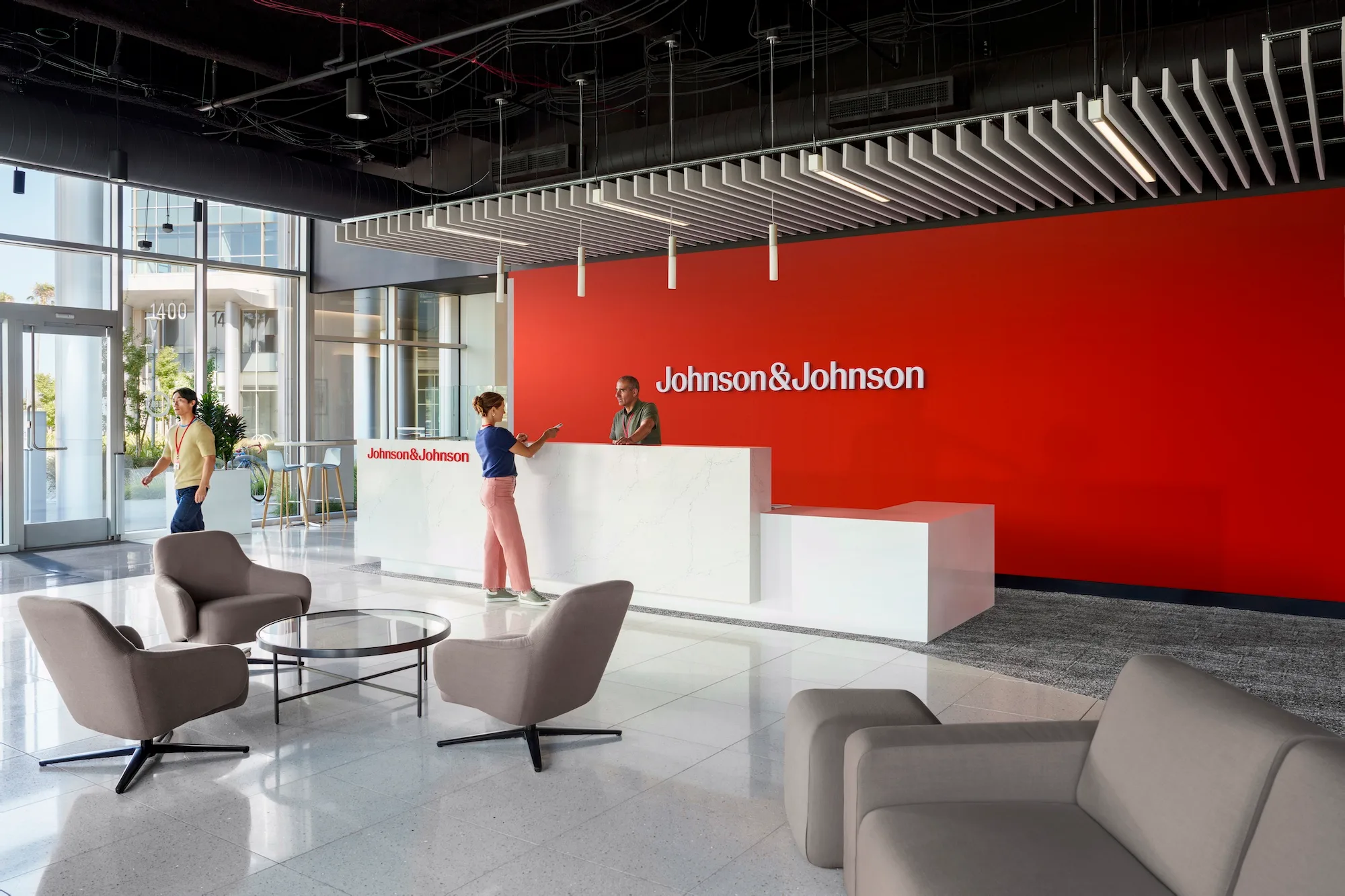 Johnson & Johnson office lobby with a red branded feature wall and stone reception desk