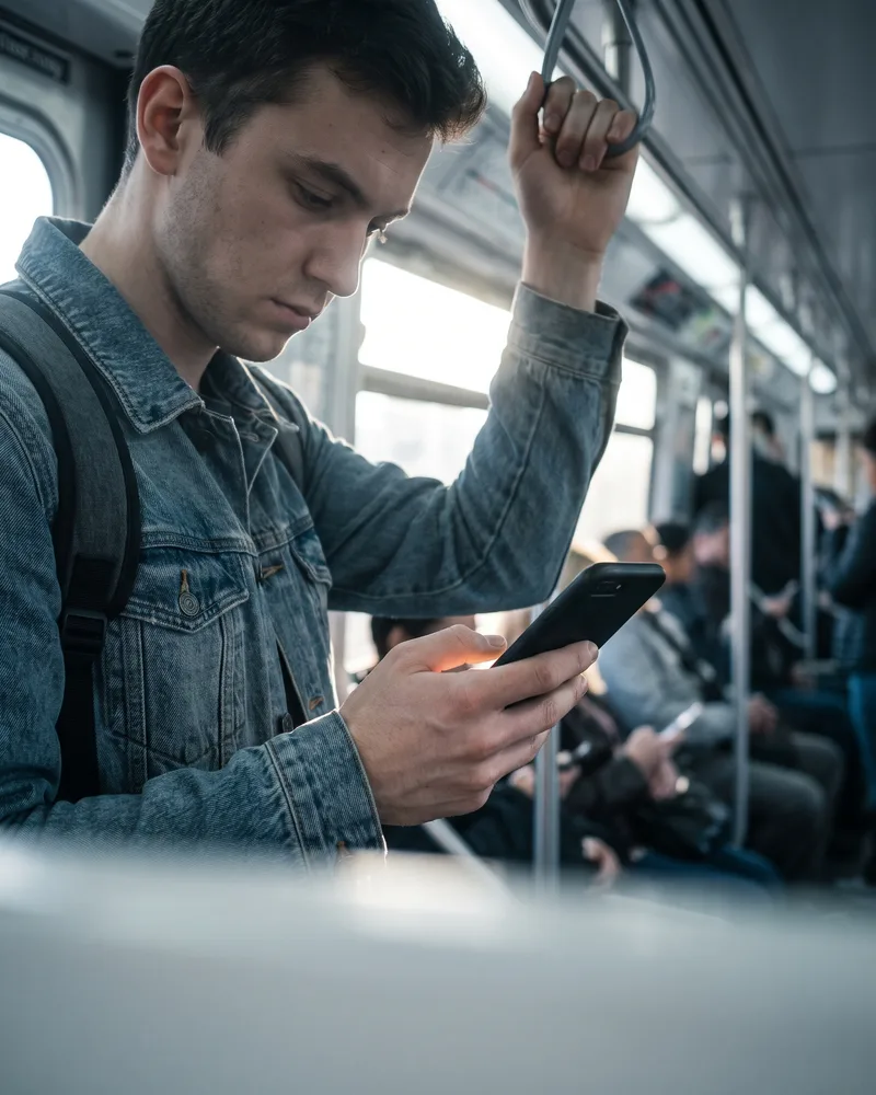 Commuter using a smartphone on a city train