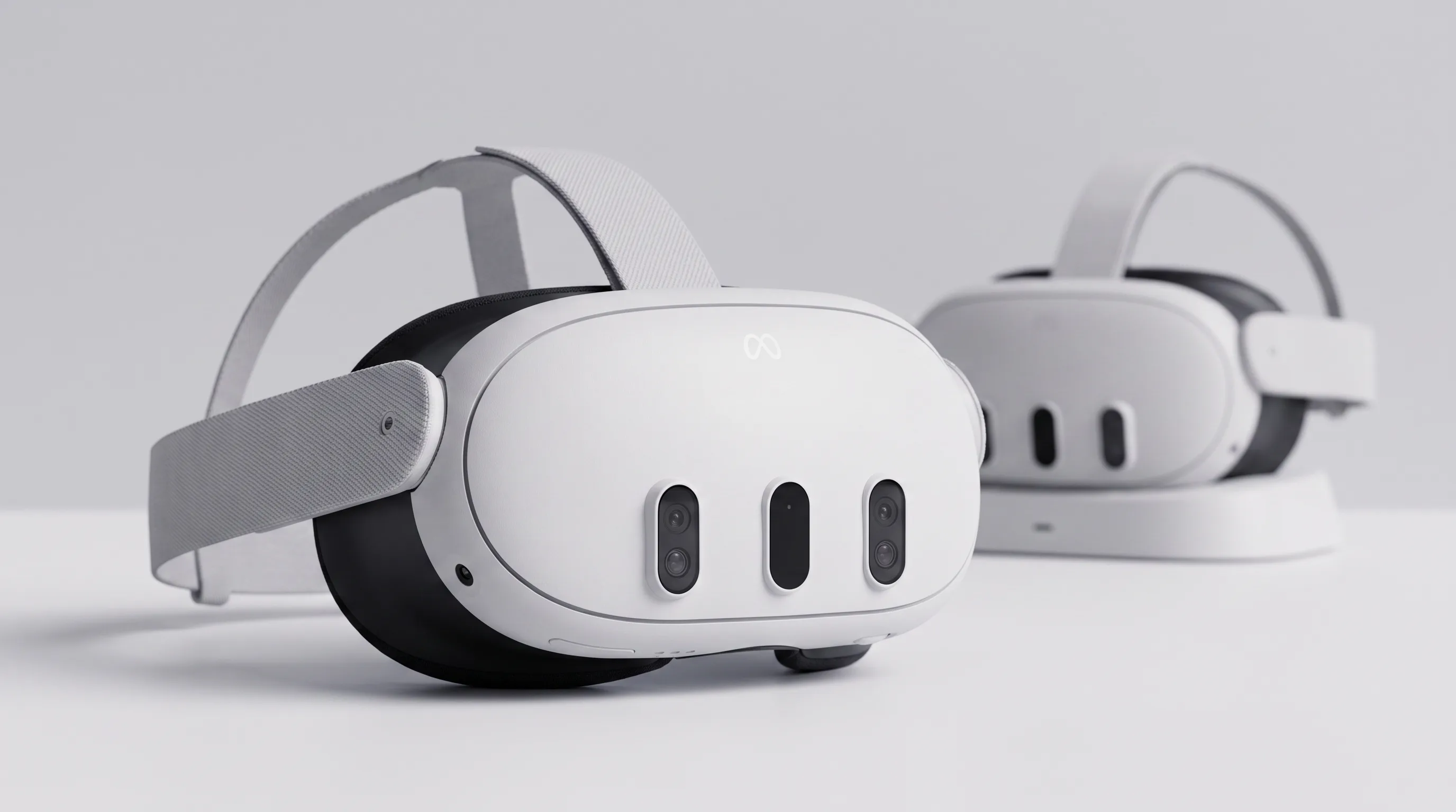 Meta Quest 3 Enterprise VR headset on a training room surface with a second headset on a charging stand behind