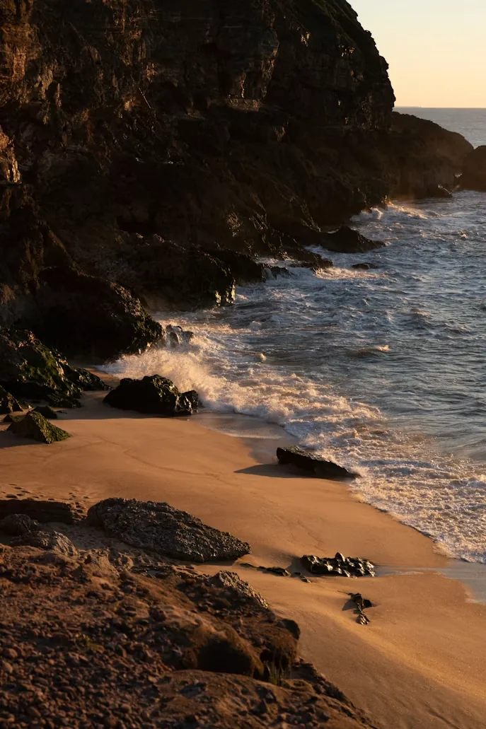 Waves breaking on a rocky cove with a golden sand beach