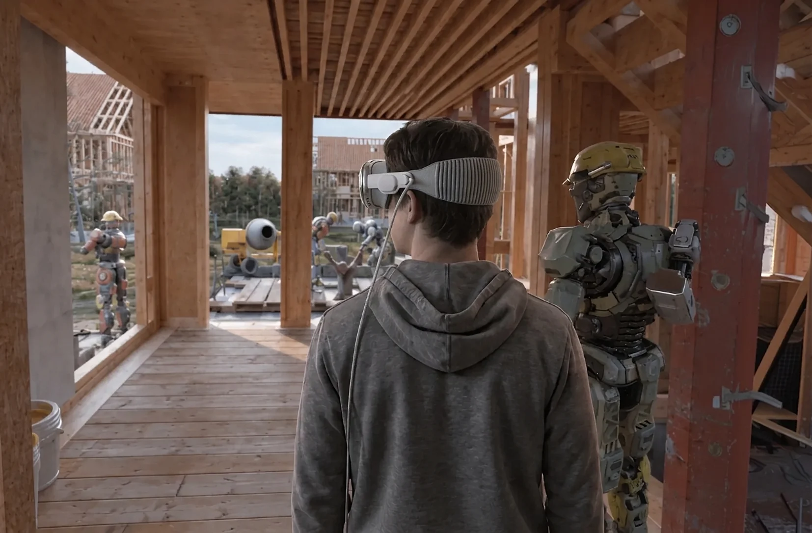 A viewer wearing Apple Vision Pro standing in a timber-framed house beside a life-size robot
